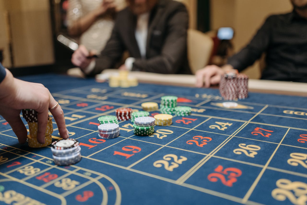 services-03 Hands placing betting chips on a roulette table in an upscale casino setting.
